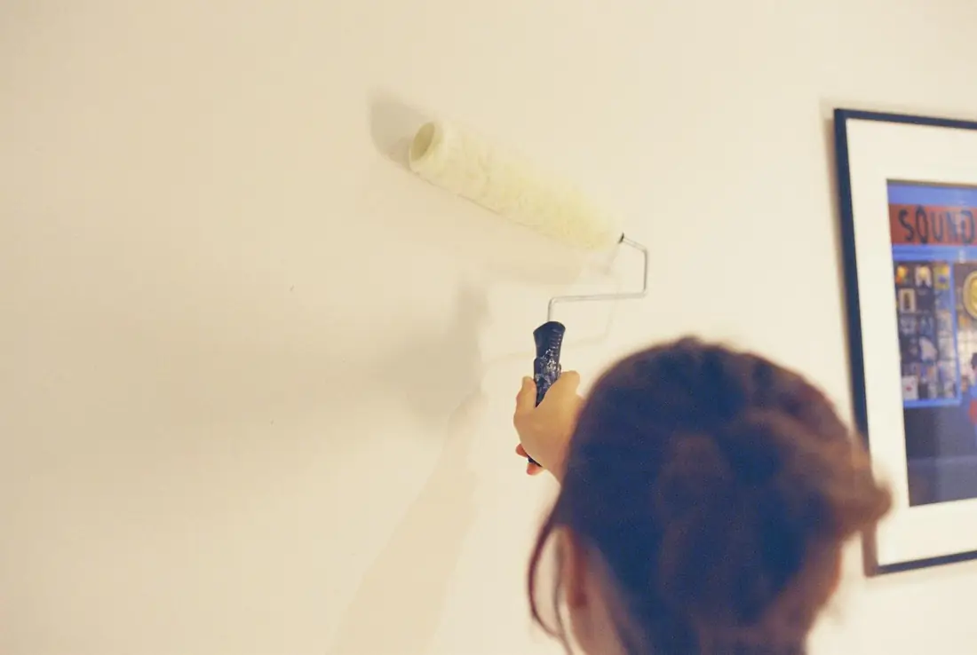 Peintre passant le rouleau sur un mur clair